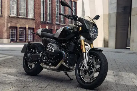 Schwarze BMW R 12 mit Café Racer Verkleidung steht auf Kopfsteinpflaster vor einer Backsteinfassade.