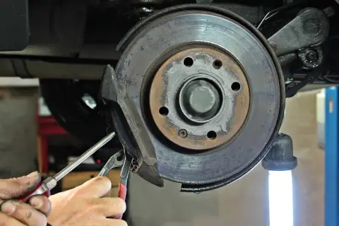 Mechaniker repariert Auto-Bremse. Bald kein Quietschen mehr!