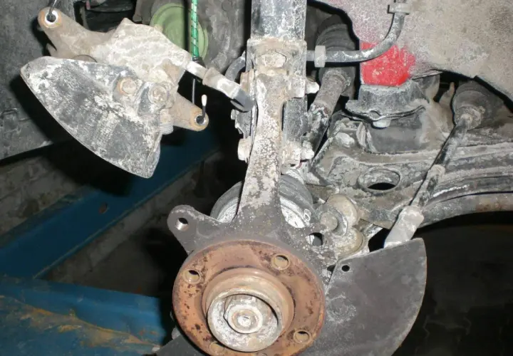 Vorderachse eines Golf 7, bereit für den Wechsel des Radlagers. Rostige Teile und Aufhängung sind sichtbar.