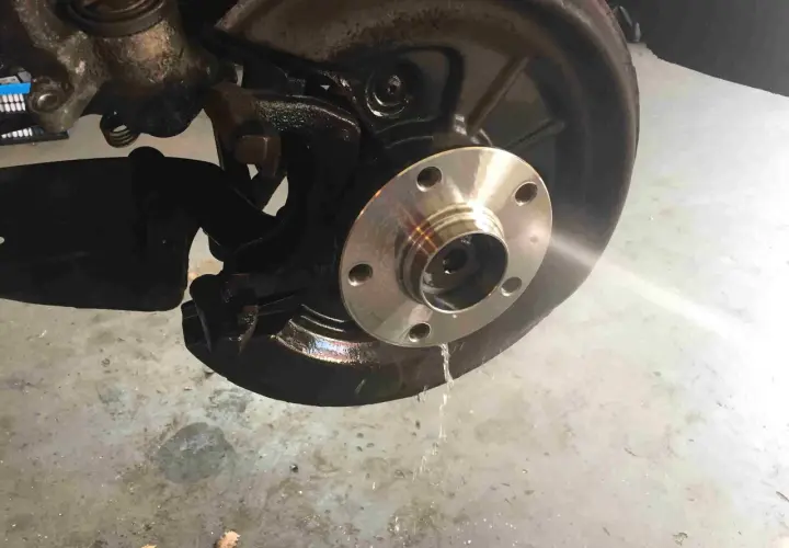 Radnabe eines Golf 5, bereit für den Wechsel des vorderen Radlagers. Flüssigkeit tropft auf den Boden.