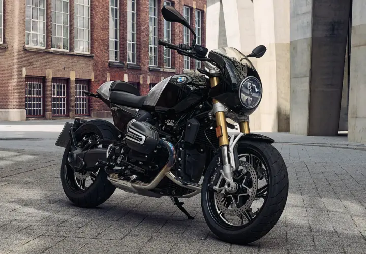 Schwarze BMW R 12 mit Café Racer Verkleidung steht auf Kopfsteinpflaster vor einer Backsteinfassade.
