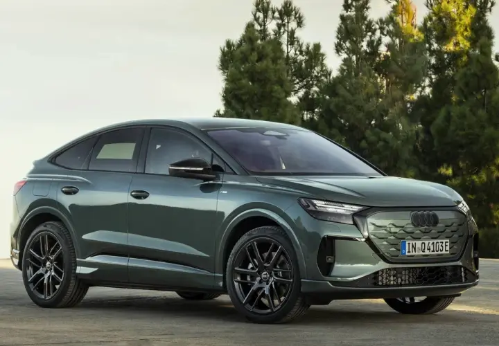 Der **Audi Q4 Facelift** in elegantem Grün steht vor Bäumen. Sein sportliches Design mit coupéhafter Dachlinie und markanten Felgen macht ihn zum Hingucker.