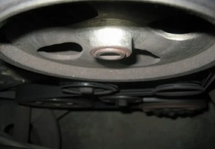 Detailaufnahme der Riemenscheiben und Keilriemen eines Peugeot 206, bereit für den Wechsel des Keilriemens.