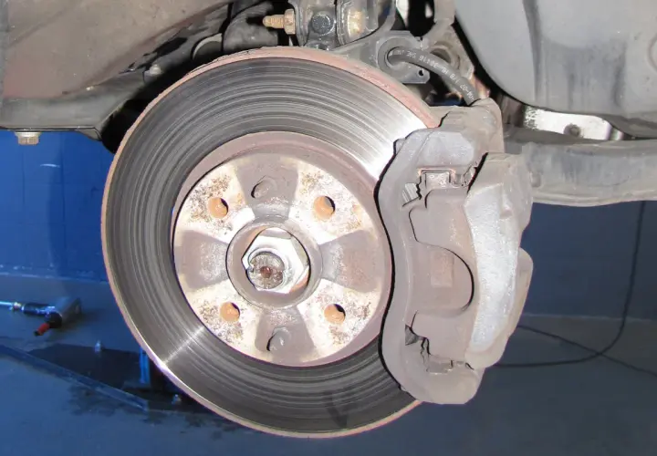 Nahaufnahme einer Bremsscheibe und eines Bremssattels. Ein Auto hat normalerweise vier Bremsscheiben.