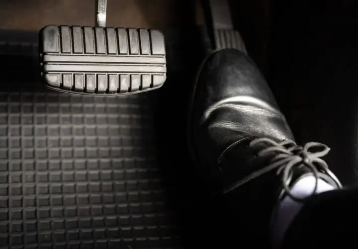 Ein Schuh steht bereit, um das Bremspedal zu betätigen. So weißt du, wo ist die bremse beim auto.