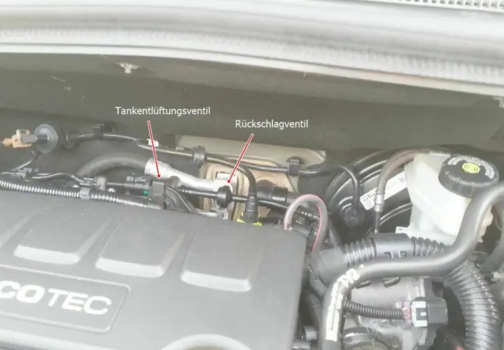 Motorraum eines Opel mit markiertem Tankentlüftungsventil und Rückschlagventil. Der Fehlercode p0171 kann hier relevant sein.