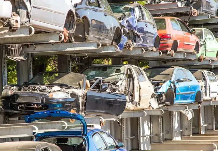 Gestapelte Autos auf einem Schrottplatz. Hier werden alte Autoteile entsorgt und für das Recycling vorbereitet.