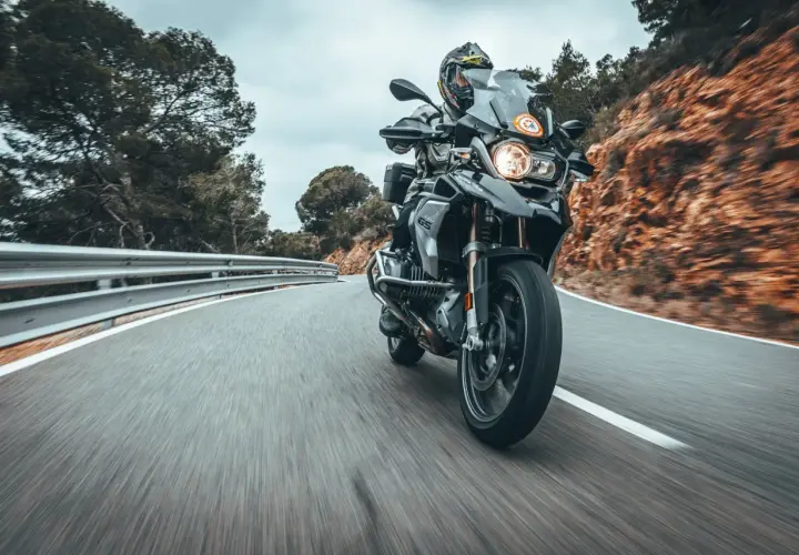 Fahrer auf einer BMW 1200 GS fährt auf einer kurvigen Bergstraße.