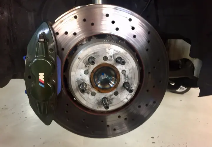Grüne Bremssättel mit M-Logo und gelochte BMW M4 F82 Bremsscheiben, bereit für Höchstleistung.