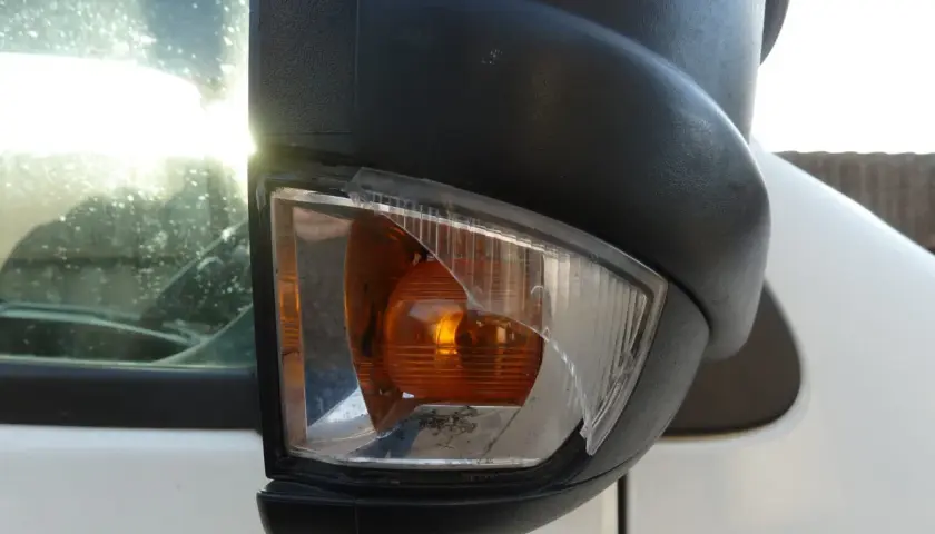 Nahaufnahme eines beschädigten Ford Transit Spiegelblinkers mit zerbrochenem Glas.