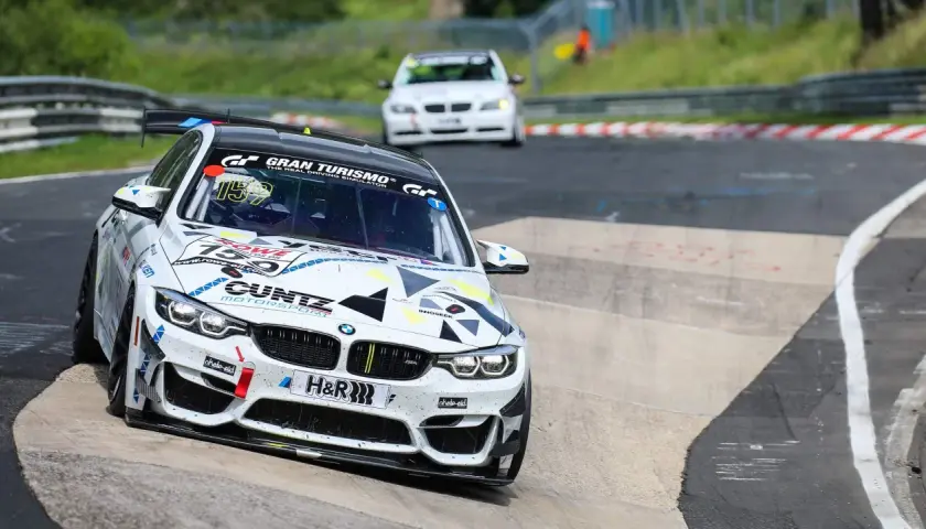Ein weißer BMW mit der Startnummer 159 auf einer Rennstrecke. Die Frage, wie viel verdient ein Rennfahrer, bleibt offen.