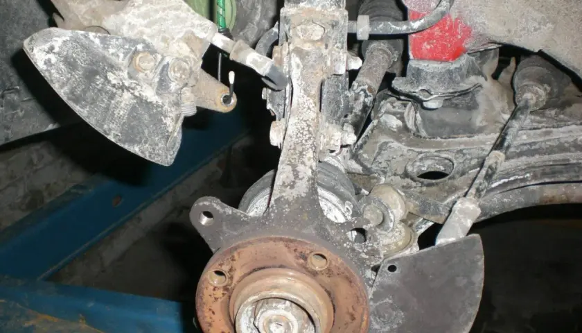 Vorderachse eines Golf 7, bereit für den Wechsel des Radlagers. Rostige Teile und Aufhängung sind sichtbar.