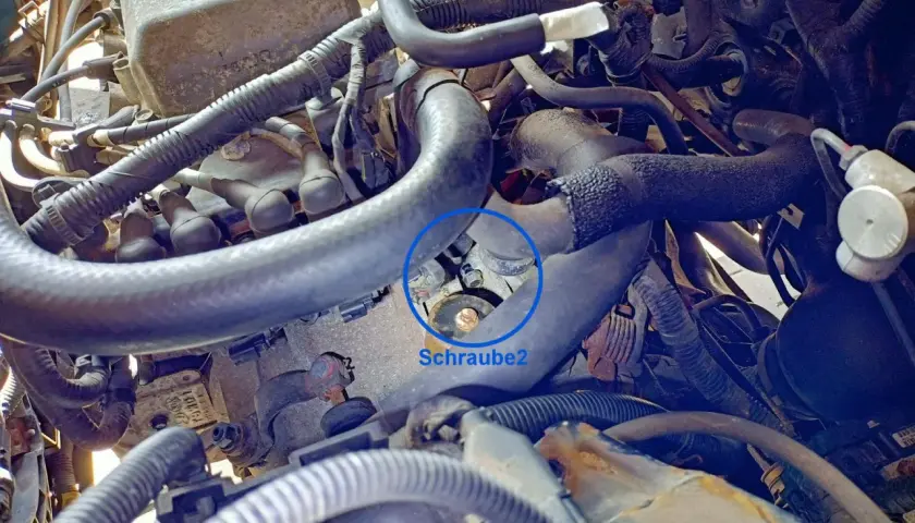 Motorraum eines Hyundai i30. Die Batterie und der Luftfilter sind entfernt. Eine Schraube am Anlasser ist markiert.