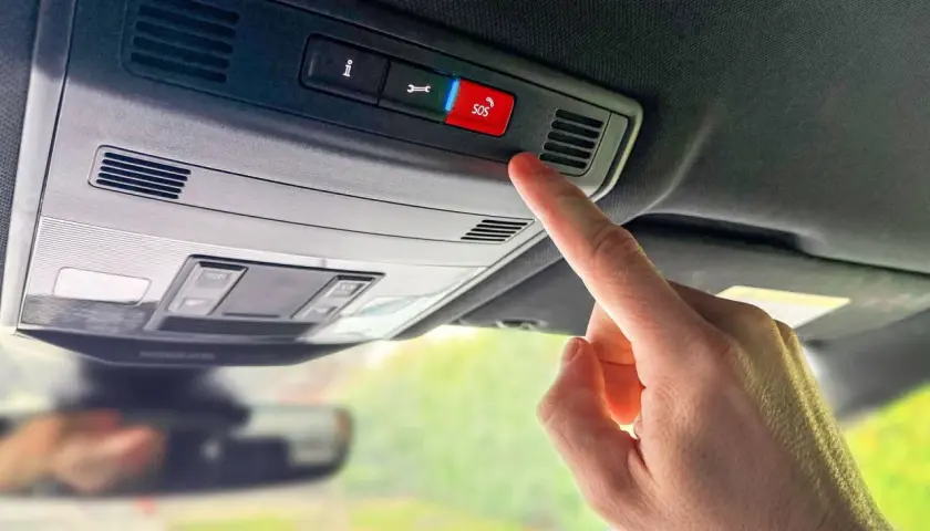 Finger drückt SOS-Knopf im Auto. In welcher Situation eCall auslöst, ist hier nicht ersichtlich, aber es ist ein Notruf.
