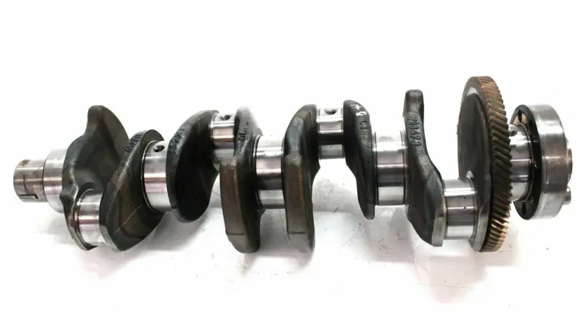 Metallische Kurbelwelle mit Zahnrad. Mögliche kurbelwelle defekt symptome sind ungewöhnliche Geräusche und Leistungsverlust.