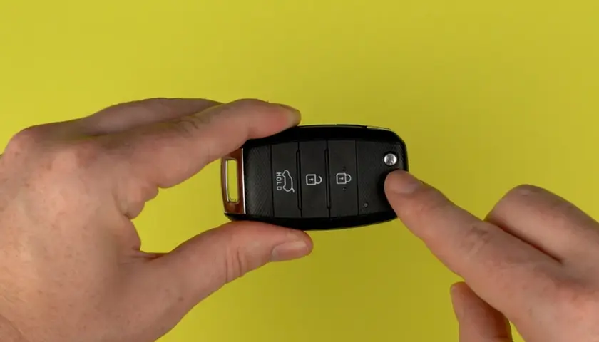 Hände halten Autoschlüssel für Kia Sportage, um die Batterie zu wechseln.