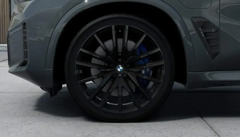 Nahaufnahme eines schwarzen BMW-Rads mit blauen Bremssätteln.