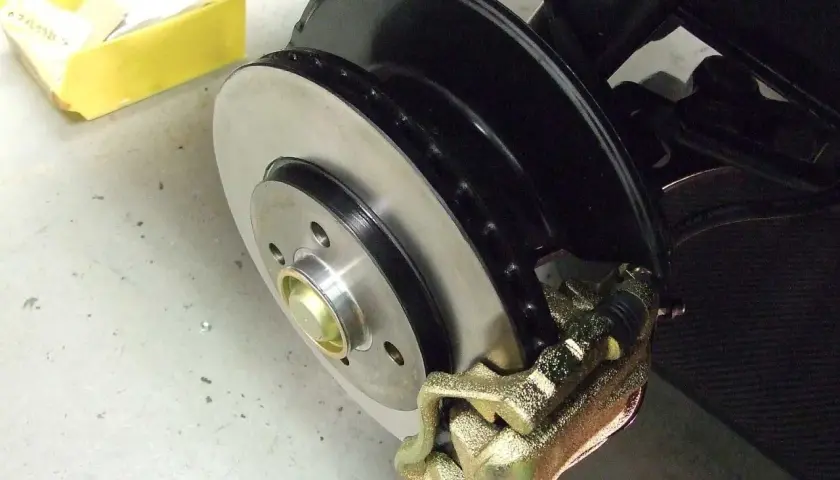 Frisch lackierte Bremsscheiben und ein goldener Bremssattel, bereit für den Einbau.