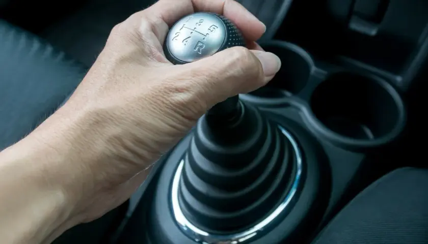 Hand schaltet mit der auto kupplung den Gang.