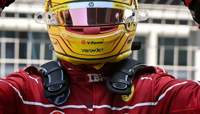Sir Lewis Hamilton feiert in seinem gelben Ferrari-Helm und rotem Rennanzug einen Sieg.