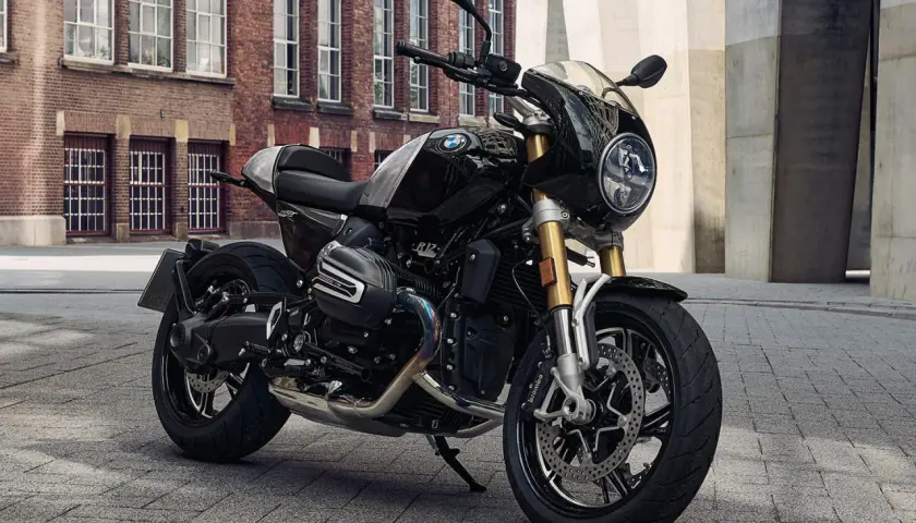 Schwarze BMW R 12 mit Café Racer Verkleidung steht auf Kopfsteinpflaster vor einer Backsteinfassade.