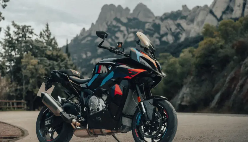 Die BMW M1000XR steht bereit für Abenteuer vor einer beeindruckenden Bergkulisse.