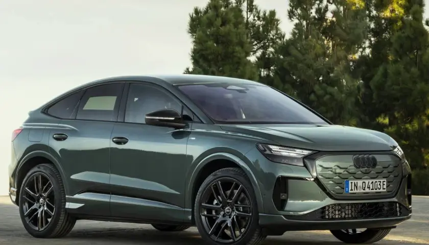 Der **Audi Q4 Facelift** in elegantem Grün steht vor Bäumen. Sein sportliches Design mit coupéhafter Dachlinie und markanten Felgen macht ihn zum Hingucker.