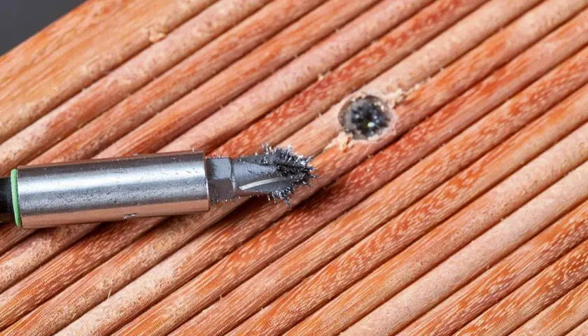 Ein Schraubenextraktor mit Metallspänen auf Holzoberfläche.