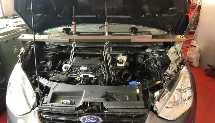 Motorraum eines Ford p0766, Motor wird mit Ketten und Stützen gehalten.