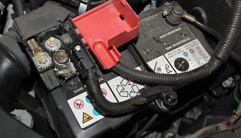 Batteriepole eines Honda Jazz, bereit für den Wechsel. Die roten Abdeckungen sind abgenommen, die Kabelanschlüsse sichtbar.