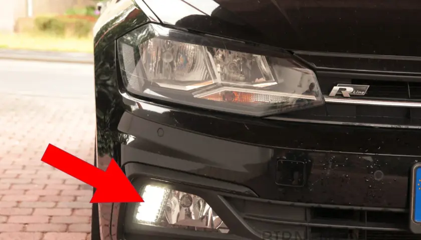 Roter Pfeil zeigt auf das Tagfahrlicht des VW Polo 6R. Hier wird die Birne gewechselt.