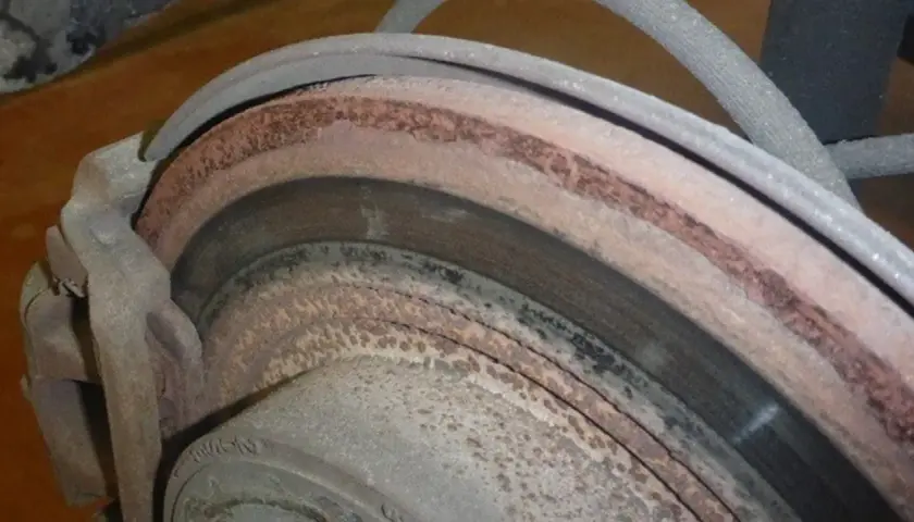 Rostige Bremsscheiben und ein Bremssattel. Die Bremsen vorne und hinten sind stark verrostet und abgenutzt.
