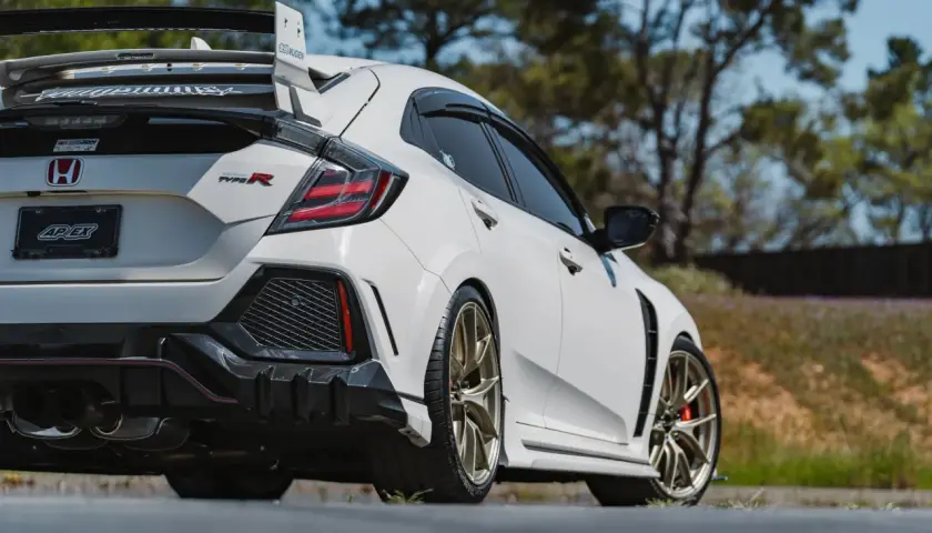 Weißer Honda Civic Type R 2018 mit goldenen Felgen und großem Heckspoiler, bereit für die Rennstrecke.