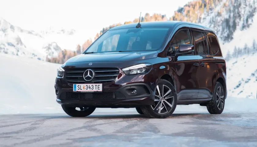 Dunkelroter Mercedes T 180 d im Schnee. Technische Daten sind hier nicht ersichtlich, aber das Fahrzeug wirkt robust für winterliche Straßen.