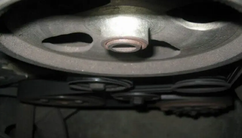 Detailaufnahme der Riemenscheiben und Keilriemen eines Peugeot 206, bereit für den Wechsel des Keilriemens.