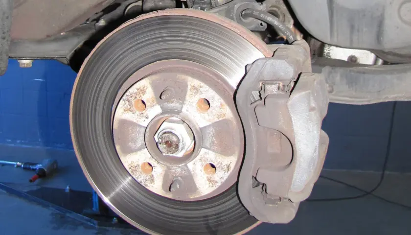 Nahaufnahme einer Bremsscheibe und eines Bremssattels. Ein Auto hat normalerweise vier Bremsscheiben.