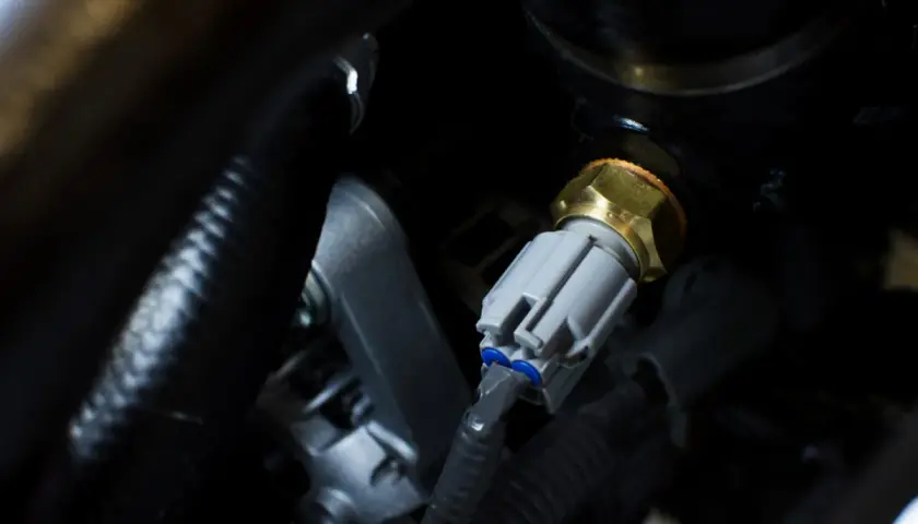 Detailaufnahme eines Temperatursensors, der für den **VW Touran 2.0 TDI Thermostat wechseln** benötigt wird.