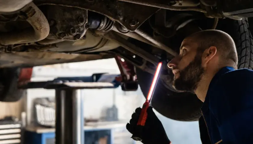Mechaniker prüft das Fahrwerk eines Autos, um sicherzustellen, dass das audi s tronic Getriebe einwandfrei funktioniert.