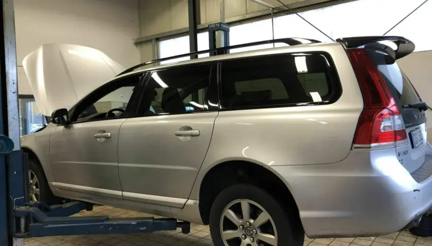 Silberner Volvo Kombi auf Hebebühne, Motorhaube offen. Gute Volvo Geartronic Erfahrungen sind wichtig für die Wartung.