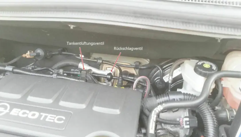 Motorraum eines Opel mit markiertem Tankentlüftungsventil und Rückschlagventil. Der Fehlercode p0171 kann hier relevant sein.