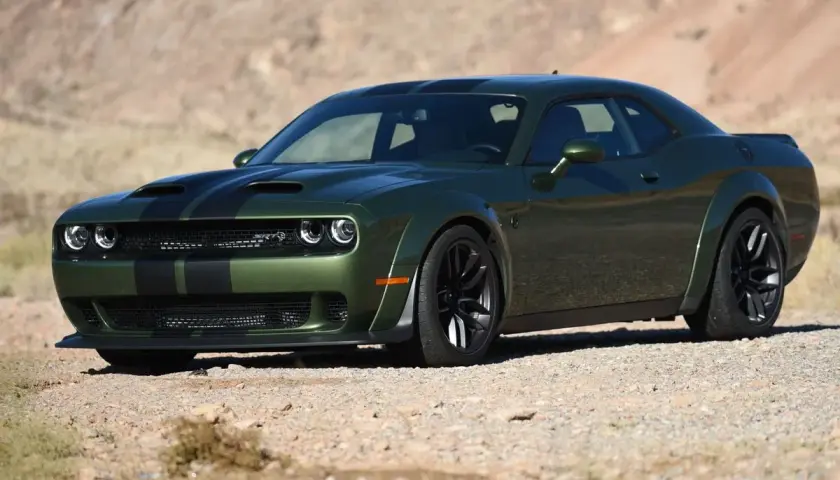 Grüner SRT Demon mit schwarzen Streifen parkt in der Wüste.