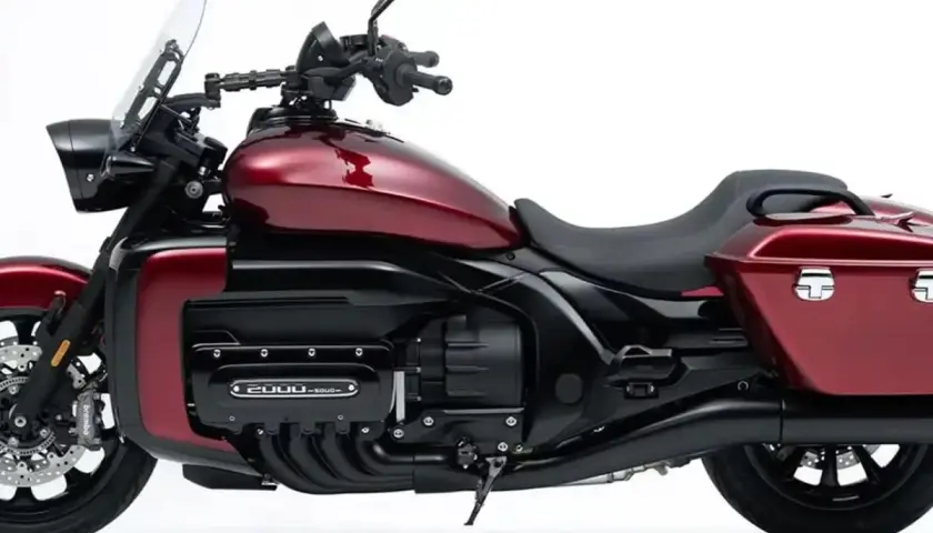 Rotes Motorrad mit großem Vierzylinder-Motor und Gepäcktaschen.