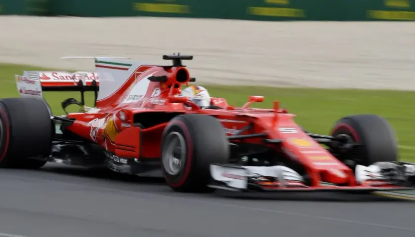 Ein roter Ferrari-Rennwagen rast über die Strecke, ein Meisterwerk der Formel 1 Technik, mit dem Fahrer im Cockpit.