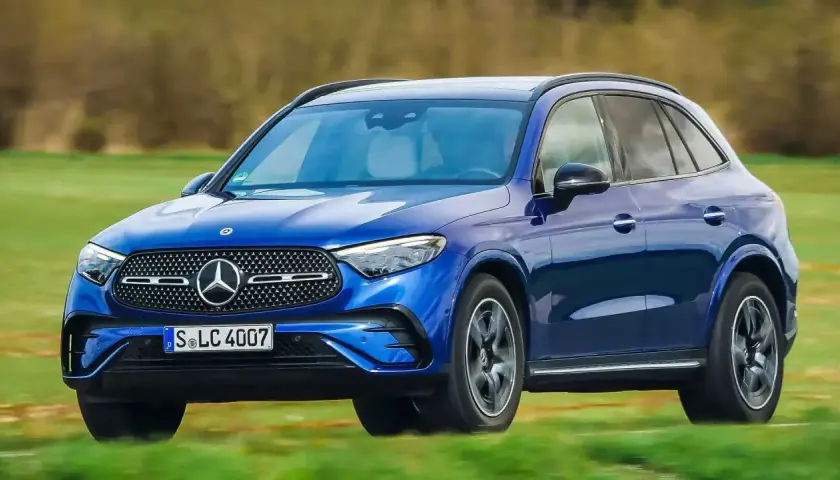 Blauer Mercedes-Benz GLC 300e PS fährt auf einer grünen Wiese.