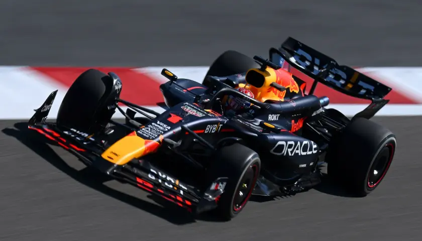 Formel 1 leistung: Ein schwarzer Red Bull Rennwagen rast über die Strecke, die Reifen drehen sich schnell.