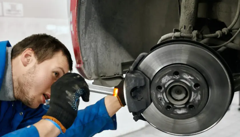Mechaniker prüft die **bremse auto links oder rechts**. Er arbeitet am Bremssattel und der Bremsscheibe.