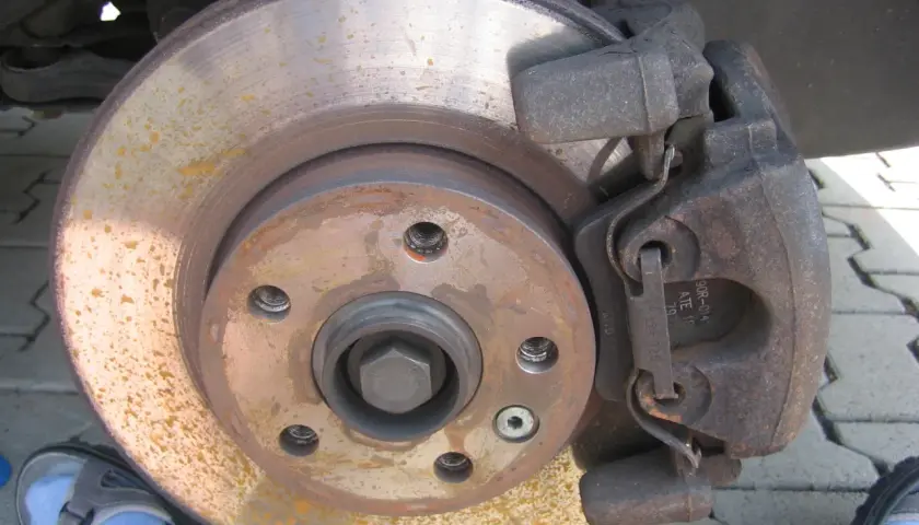 Bremsbeläge und Bremsscheibe zeigen Rostspuren. Das Auto klackert beim Bremsen, was auf Verschleiß hindeutet.