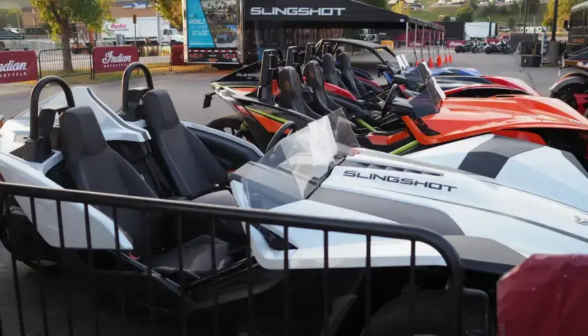 Mehrere bunte Slingshot-Autos stehen nebeneinander, bereit für eine aufregende Fahrt.