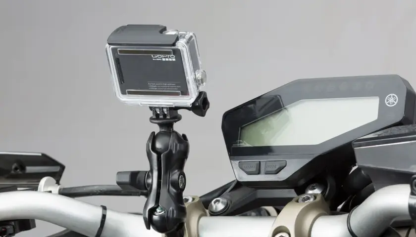 GoPro am Motorrad-Lenker montiert, bereit für actionreiche Aufnahmen. Das Display des Motorrads ist daneben zu sehen.