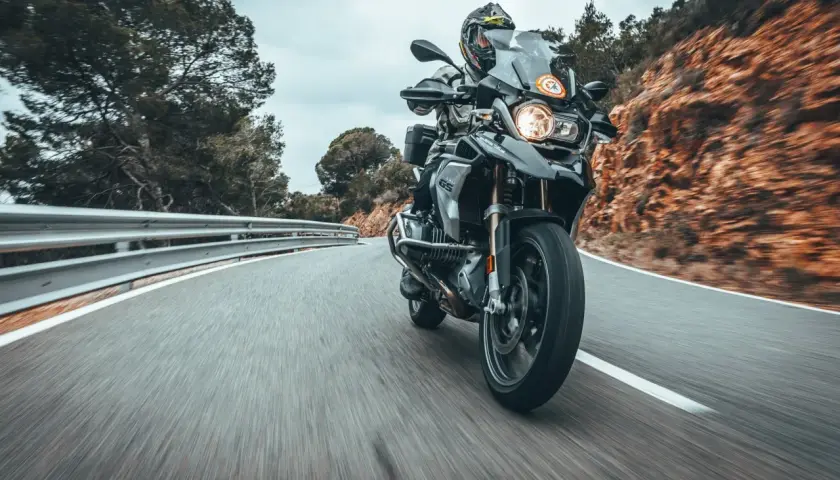 Fahrer auf einer BMW 1200 GS fährt auf einer kurvigen Bergstraße.